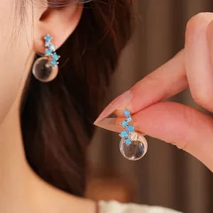 Elegant silver needle earrings featuring blue zircons and clear resin round pendants for women