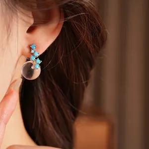 Elegant blue zircon and round resin stud earrings worn on ear for minimalist style