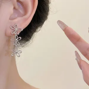 Elegant minimalist silver hollow flower tassel drop earrings for women shown on ear