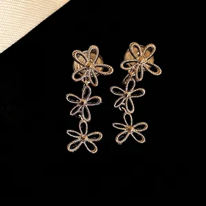 Elegant hollow gold flower tassel ear clips featuring a minimalist aesthetic design