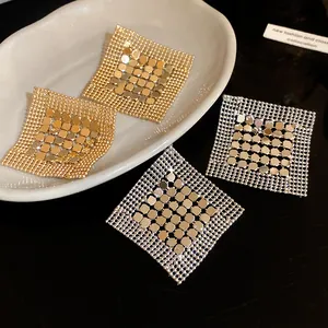 Close-up of geometric square sequin mesh earrings in gold and silver finish