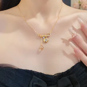 Detail view of a luxury 24k gold plated necklace with zirconia safety pin and star charms