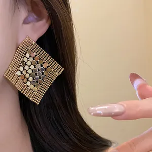 Close-up detail of gold geometric square sequin earrings with mesh fringe design for women