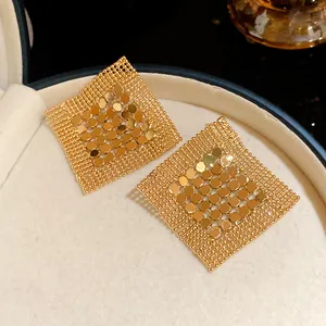 Detail view of gold geometric square sequin mesh earrings in a premium jewelry box