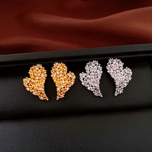 Detailed view of 18k gold and silver plated heart stud earrings with cubic zirconia stones