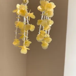 Yellow petal tassel earrings with 18k gold plated silver needles and beads.