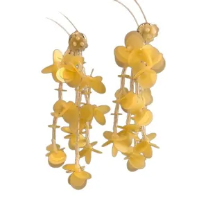 Elegant handmade yellow glass bead tassel earrings with sequin petals on white background