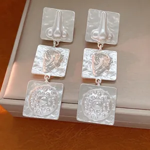 Unique geometric square drop earrings with anatomical nose and ear patterns in silver.