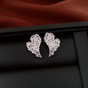 Close-up detail of luxury heart stud earrings with shimmering pave zircon stones