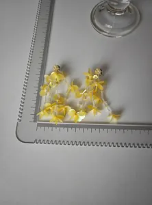 Close-up measurement detail of elegant yellow floral glass bead tassel earrings with scale