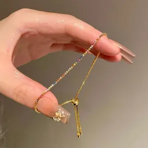 Gros plan d'un bracelet en or avec des zircons multicolores et un fermoir ajustable