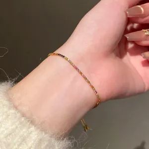 Gros plan d'un délicat bracelet en zircon arc-en-ciel porté au poignet d'une femme