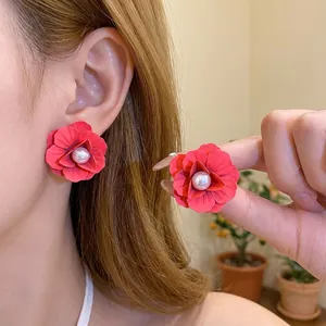 Elegant vibrant red spray-painted flower stud earrings with pearl centers for women.