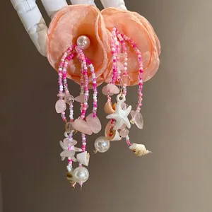 Romantic peach fabric flower tassel earrings with pearls, shells, and starfish charms