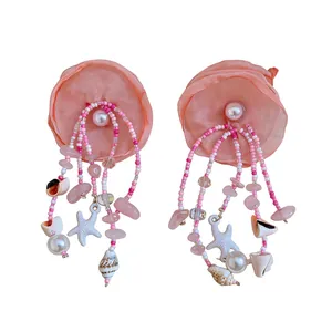 Elegant pink fabric flower tassel earrings featuring ocean shells and pearl accents