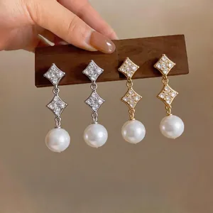 Elegant 18K gold-plated starburst earrings with sparkling zirconia and white pearl drops