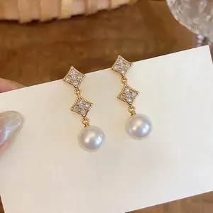 Elegant 18K gold plated star zircon and pearl drop earrings displayed on a card