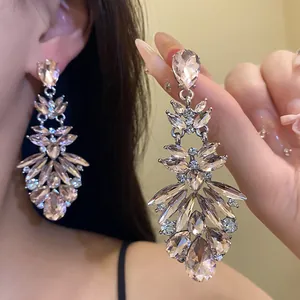 Detail view of sparkling champagne teardrop rhinestone chandelier earrings for women.