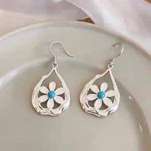 Silver flower teardrop hollow earrings with white petals and turquoise center