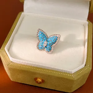 Close-up of elegant blue butterfly ear clip with sparkling cubic zirconia pavé design.