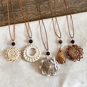 Close-up of handmade woven rattan pendant necklaces with leather cords and wooden beads