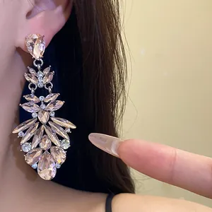 Detailed view of elegant silver needle teardrop earrings with sparkling pink rhinestones