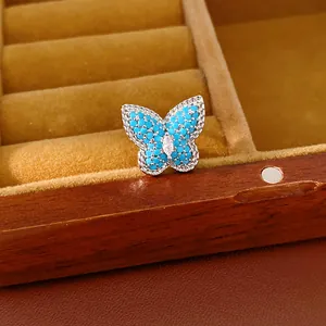 Detailed view of a silver butterfly ear clip with blue stones and a clear zircon center.