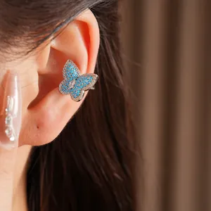 Close-up showing zircon-encrusted blue butterfly ear cuff on a model's ear