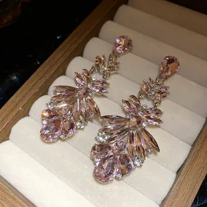 Detail view of long pink marquise-cut crystal earrings in a soft velvet jewelry box