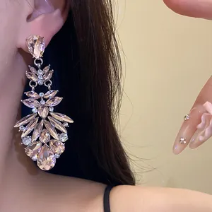 Elegant champagne crystal drop earrings shown in a detailed close-up ear view