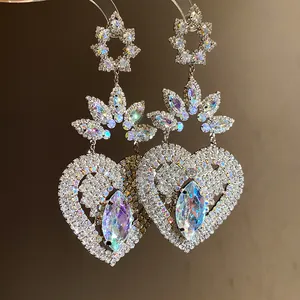 Vista detallada de pendientes de corazón vintage con cristales iridiscentes y strass