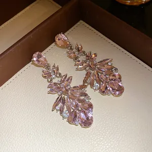 Elegant pink water drop dangle earrings with sparkling crystals in close-up detail