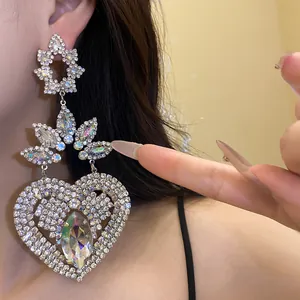 Primer plano de pendientes vintage con colgante de corazón y flores de strass en la oreja