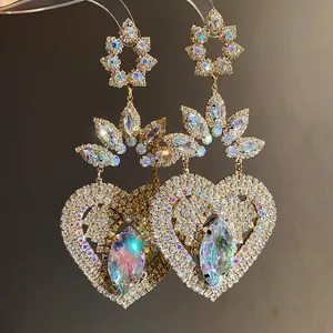 Primer plano de pendientes vintage de corazón con brillantes pedrería y piedras luminiscentes