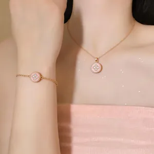 Primo piano dell'elegante collana con ciondolo a fiore rosa e braccialetto coordinato.