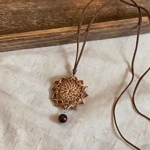Detail of a vintage handcrafted rattan star pendant necklace with a leather cord