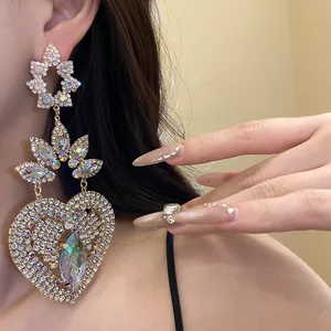 Primer plano de pendientes largos de corazón con diamantes de imitación vintage de lujo.
