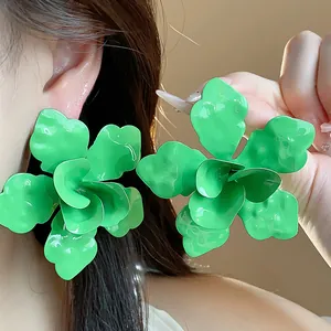 Detailed macro view showing the texture of vibrant green enamel flower stud earrings