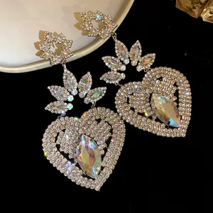 Primer plano de pendientes vintage de corazón con pedrería brillante y aguja de plata
