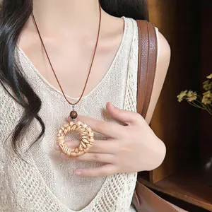 Handcrafted vintage woven rattan pendant necklace with brown leather cord shown on model