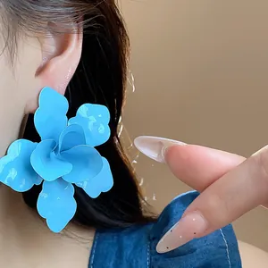 Detailed close-up view of a large blue flower earring with a vibrant matte finish