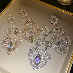 Detalle de pendientes vintage de lujo con forma de corazón, pedrería y piedras irisadas