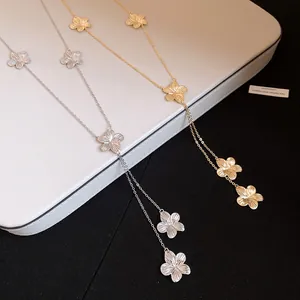 Detalle de collares con colgantes de flores en metal dorado y plateado con borlas