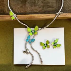 Detail view of a butterfly jewelry set with green enamel and sparkly rhinestones