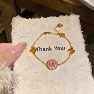 Dettaglio di un bracciale a fiori placcato oro 18k con inserto rosa e pietre di zircone