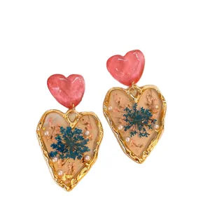 Elegant heart drop earrings with blue dried flowers and pearls in golden frames
