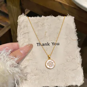 Vista dettagliata di una collana placcata oro 18 carats con ciondolo a fiore in zircone.