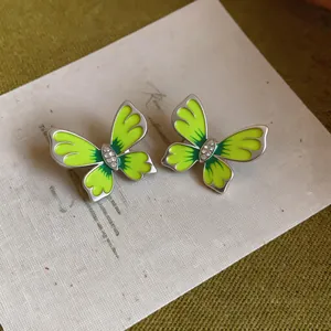 Detailed macro view of enamel butterfly earrings with sparkling center stones