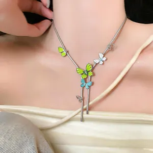 Detailed macro view of a silver-toned necklace with vibrant enamel and crystal butterfly charms