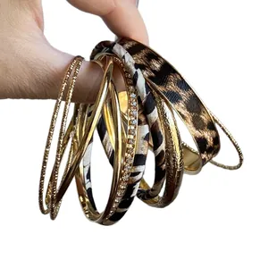 Elegant set of leopard print leather and gold metal stackable bracelets in retro fashion style
